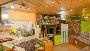 A kitchen with a wooden ceiling, a sink, a stove, and a dining area with stools. - Finca "La Alpispa" with Pool, Fast Wi-Fi, Terrace & Garden (Valleseco)