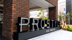 A brick building with large, bold letters spelling "PROSINE" on the facade. - PROSTYLE Ryokan Naha Kenchomae (Naha)