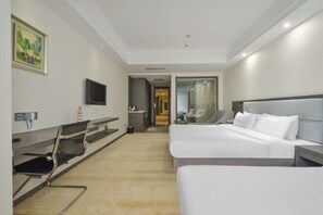Une chambre d’hôtel avec un lit, un bureau, une chaise, une télévision et un tableau au mur.