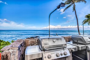 Enjoy al fresco dining with a barbecue grill setup overlooking the ocean and palm trees.