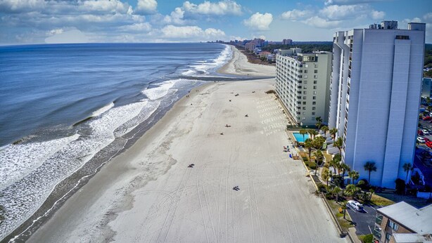 A beachside hotel with a long beachfront, a parking lot, and a pool area. - Oceanfront 5th floor,quiet,peaceful.beautiful views (Myrtle Beach)
