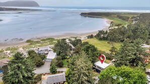 Zona residencial costera con casas, una playa y una extensa masa de agua.