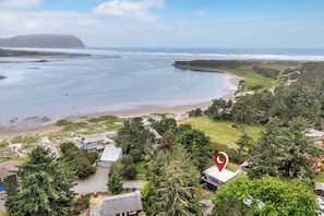 A coastal residential area with houses, a beach, and a large body of water.