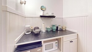 Eine Küche mit Kaffeemaschine, Mikrowelle, Toaster und einem kleinen Schrank.