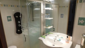 A bathroom with a glass-enclosed shower, a white sink with a mirror, and a toilet. - Small resin house (Arcachon)
