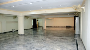 A spacious hall with a polished marble floor, white walls, and a ceiling with recessed lighting. - Mirage Hotel (Lahore)