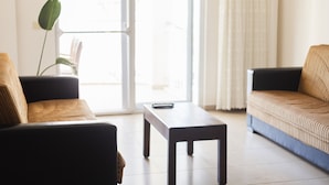 A modern living room with two sofas, a coffee table, and a potted plant. - Kaju Rooms (Marmaris)