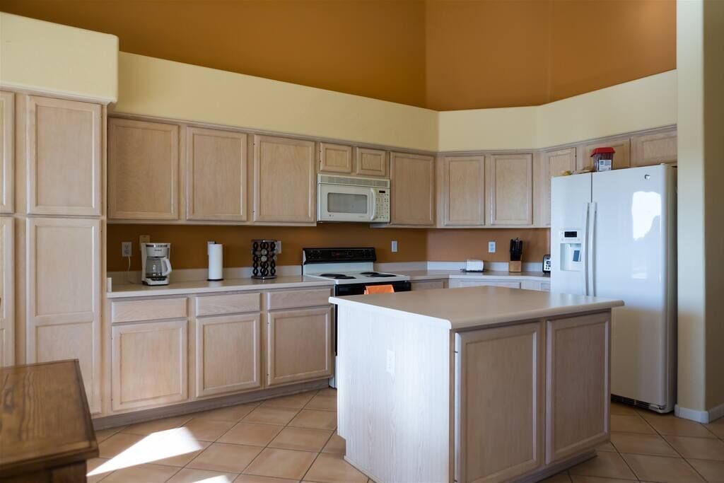 A kitchen with wooden cabinets, a microwave, a stove, and a refrigerator.