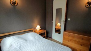 A bedroom with a bed, bedside tables, a dresser, and a mirror. - T2 Bis Apartment for 6 People with Parking in Cauterets (Cauterets)