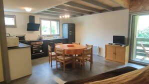 A compact kitchen with a dining area, a TV on a cabinet, and a window providing natural light. - T2 Bis Apartment for 6 People with Parking in Cauterets (Cauterets)