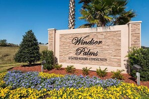 Windsor Palms resort community entrance features a beautifully maintained flower bed and a stone wall.