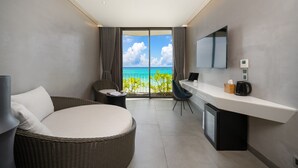 Une chambre d’hôtel moderne dotée d’un balcon, d’un grand lit, d’un bureau et d’une télévision.