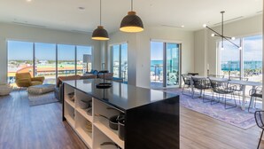 A modern kitchen with a large island, built-in shelves, and pendant lighting. - 5 BR, Sits directly on the beach, rooftop pool! (Gulf Shores)