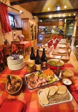 Comedor con una mesa larga dispuesta para una comida, mostrando diversos platos y botellas.