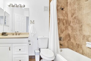 A bathroom with a toilet, sink, and bathtub.