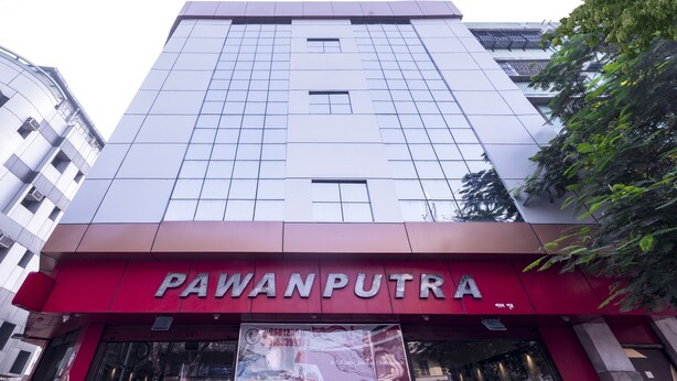 Un edificio con toldo rojo y el nombre "PAWANPUTRA" en la fachada.