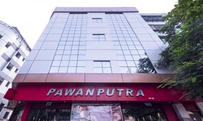 Un edificio con toldo rojo y el nombre "PAWANPUTRA" en la fachada.