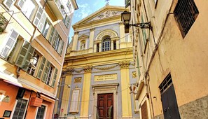 A narrow street with buildings featuring classical architecture, including a prominent building with a sign reading 'DIVO JACOBO MAJORI APOSTOLO'. - New! N&J - LOU NISSART - Heart of the Old Town (Nice)