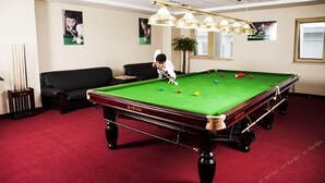A pool table with balls, a black sofa, and a billiard cue. - Guizhou Mansion (Beijing)
