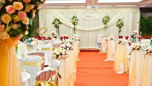 A banquet hall with rows of tables, each adorned with white tablecloths and floral centerpieces. - Guizhou Mansion (Beijing)