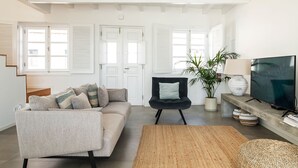A living room with a sofa, a chair, a television, and a plant. - Town house in Silves (Silves)