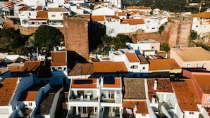 A coastal town with terracotta-roofed buildings, a prominent church, and a swimming pool. - Town house in Silves (Silves)
