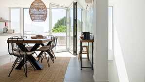 A modern dining area with a large table, chairs, and a hanging light fixture. - Town house in Silves (Silves)