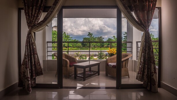 Una habitación con vista a un balcón, una mesa y dos sillas.
