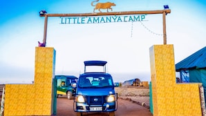 Un vehículo entra en un campamento, con un cartel que dice 'Little Amanyacamp'.