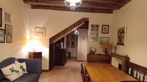 Ein gemütliches Wohnzimmer mit einem blauen Sofa, einem Holzesstisch und einer Treppe, die in einen anderen Raum führt.