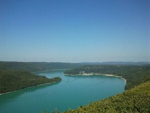 A panoramic view of a lake surrounded by forested hills. - Gîte de L'abbaye (Gigny)
