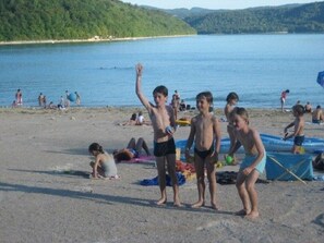 Une plage avec des gens, un bateau et un lac.