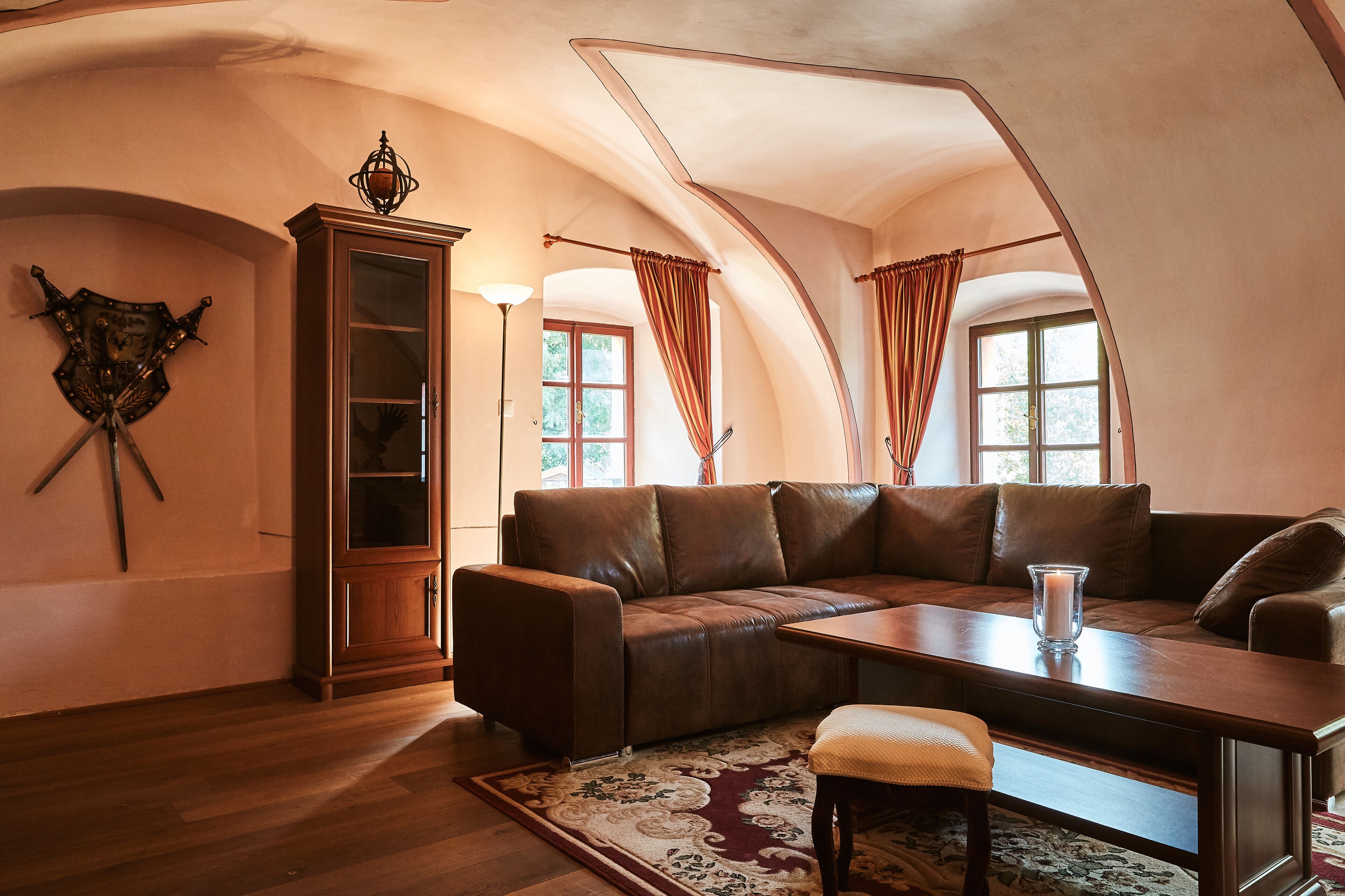 Una sala de estar acogedora con un sofá de cuero marrón, una mesa de centro de madera y un tapete estampado.