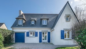 A two-story house with a steep gabled roof, a gravel driveway, and a blue door. - Charming house for 11 people in Sarzeau (Sarzeau)