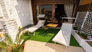 A patio with white lounge chairs, a small table, and a wooden deck. - SWEET EMOTIONS ROOM 81 (Bari)