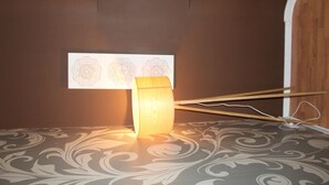 A room with a patterned carpet, a wooden lamp, and a wall with decorative panels. - SWEET EMOTIONS ROOM 81 (Bari)
