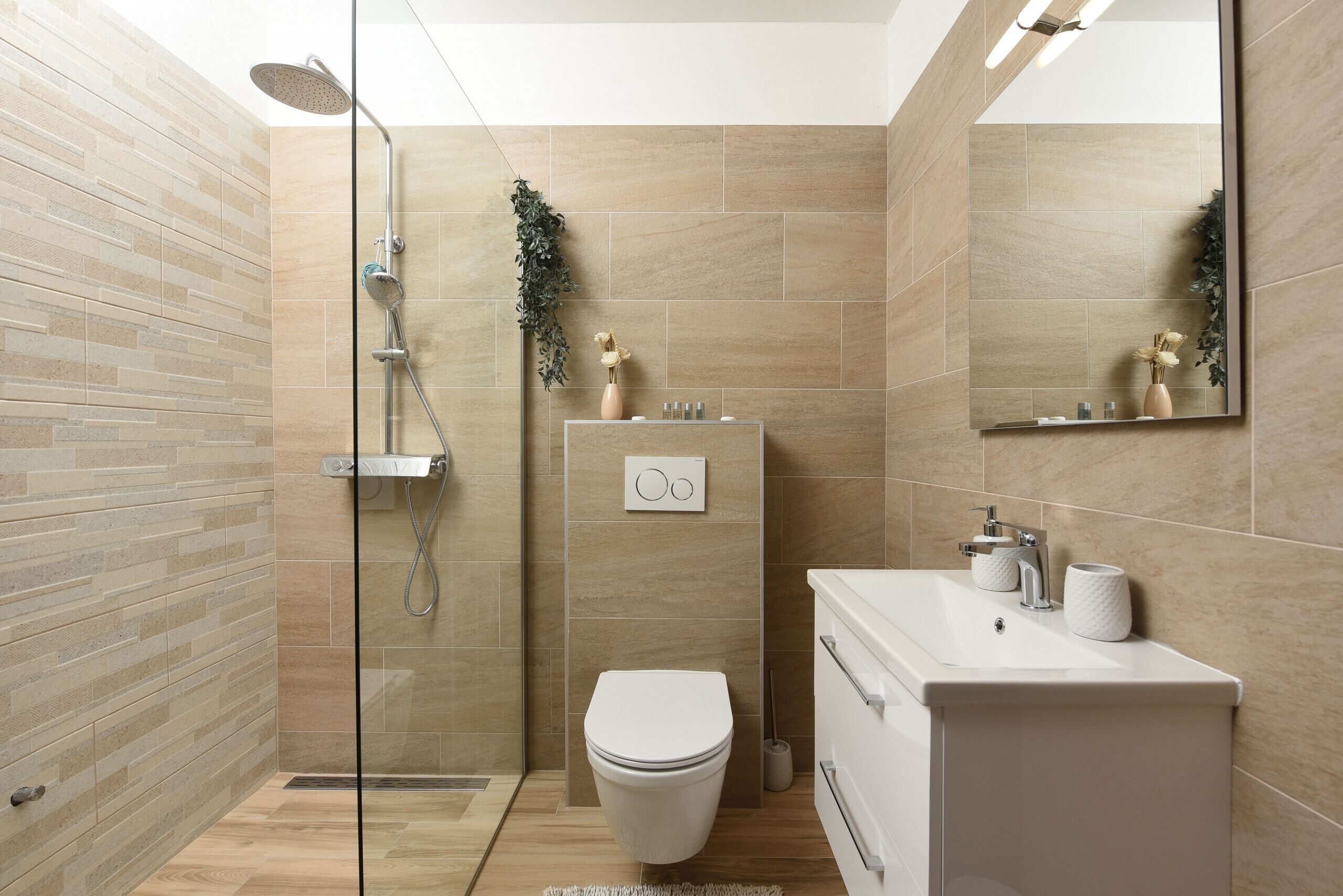 A modern bathroom with a glass shower enclosure, a toilet, and a sink with a mirror.