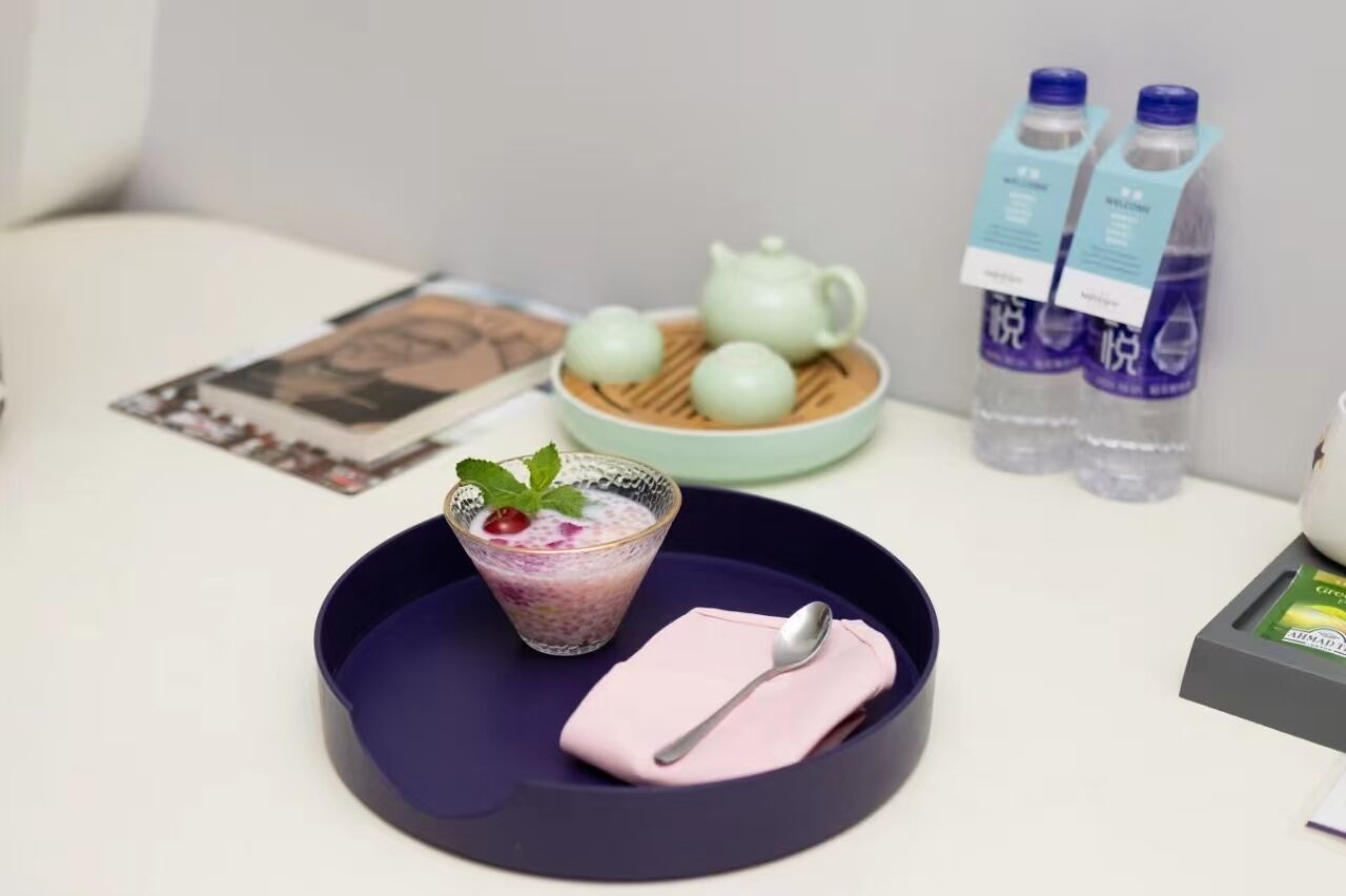 Une table avec un verre de dessert, une théière et une bouteille d’eau.