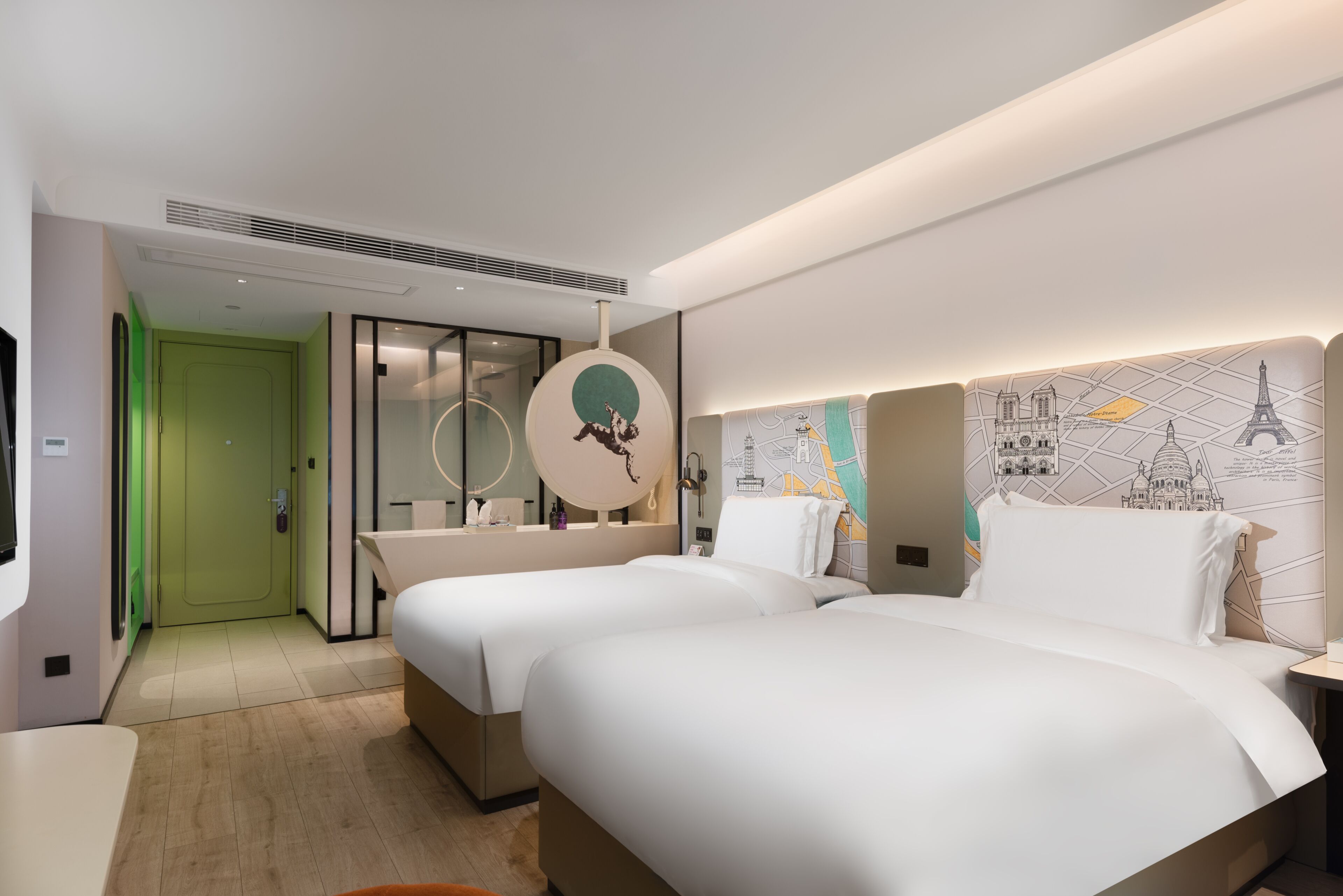 A hotel room with two beds, a green door, a mirror, and a wall with a map design.
