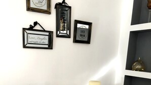 A dining table with a woven placemat, two candle holders with candles, a basket of almonds, and decorative jars. - Rosy's House (Χανιά)