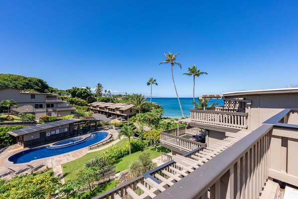 A resort with a swimming pool, palm trees, and a view of the ocean. - OCEAN VIEW 2 Bdrm condo with Secluded Beach - Kahana Sunset C7 (Lahaina)