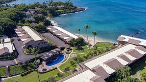 Ein Resort mit mehreren Gebäuden, einem Swimmingpool und Blick auf den Ozean.