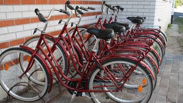 A row of red bicycles parked against a brick wall.