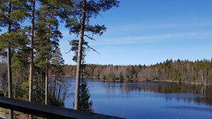 Un lac entouré d’arbres, vu depuis une terrasse en bois.