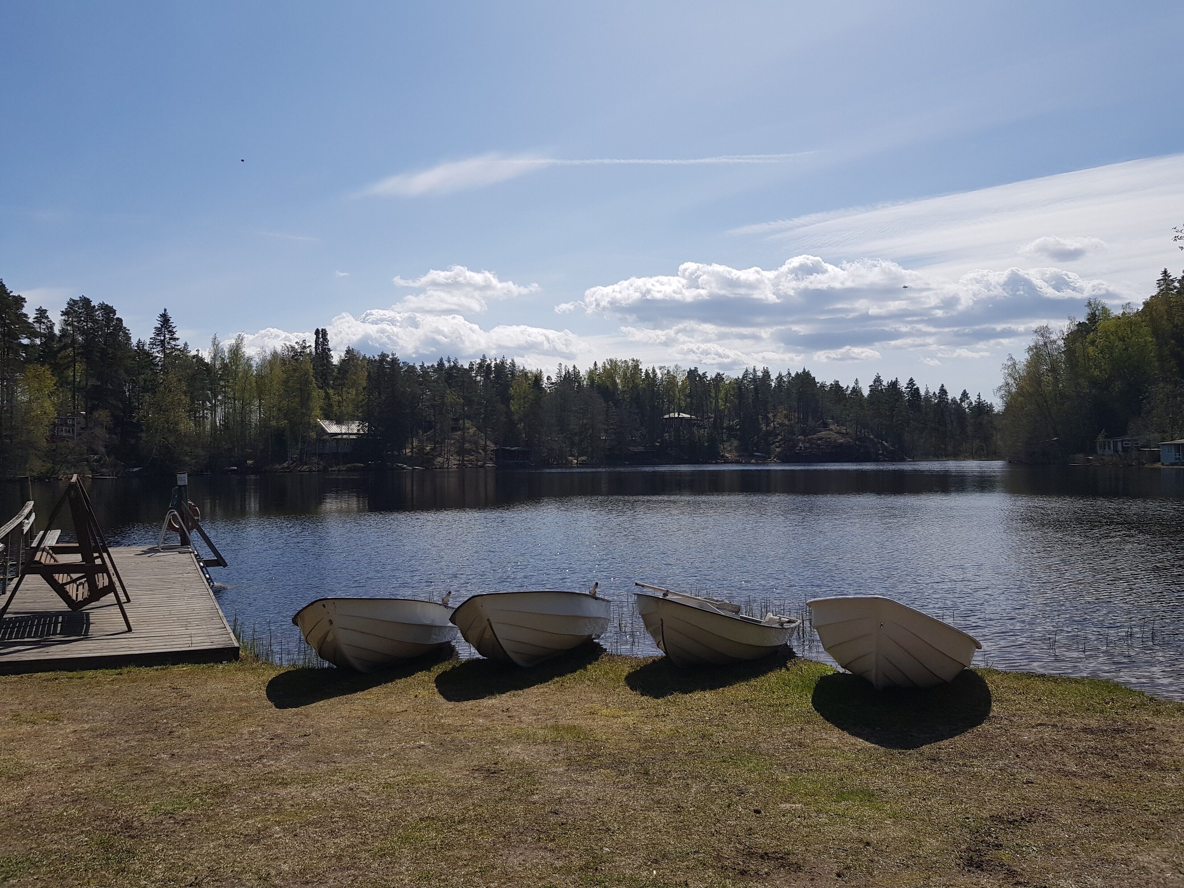 Vista para o lago com um cais e quatro barcos.