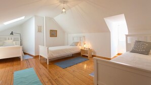 Ein Schlafzimmer mit zwei Betten, einem Oberlicht und einem Deckenventilator.