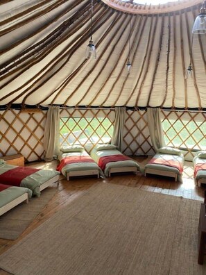 Relax in a traditional yurt with a central seating area and low table, perfect for communal dining or socializing.