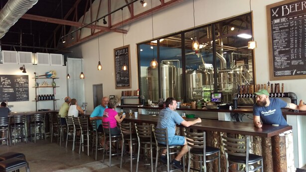 A bar with stools and a counter, a chalkboard menu, and industrial-style lighting. -  Downtown Safety Harbor 2 Bed 1 Bath Pool Home, 20 minutes from Clearwater beach (Safety Harbor)