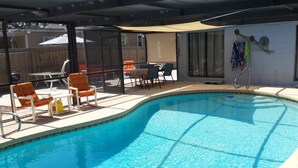 A swimming pool with lounge chairs and a covered patio area. -  Downtown Safety Harbor 2 Bed 1 Bath Pool Home, 20 minutes from Clearwater beach (Safety Harbor)
