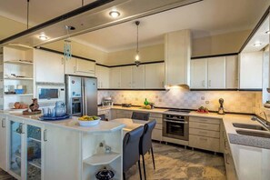 Een moderne keuken met een centraal eiland, inbouwapparatuur en een eethoek.